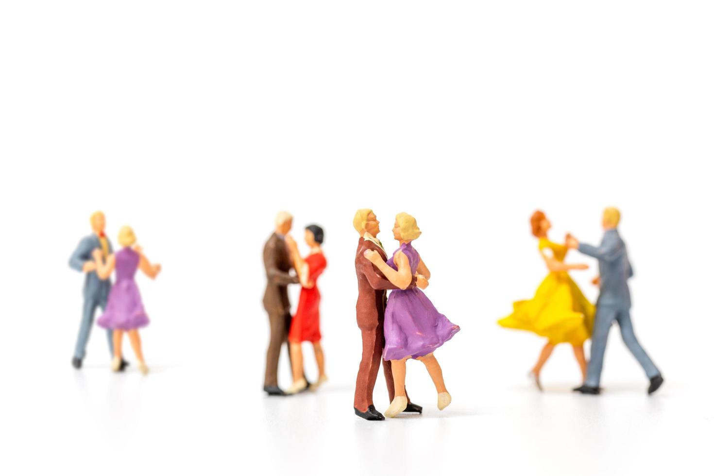 Gente en miniatura bailando sobre fondo blanco, concepto de día de San Valentín foto