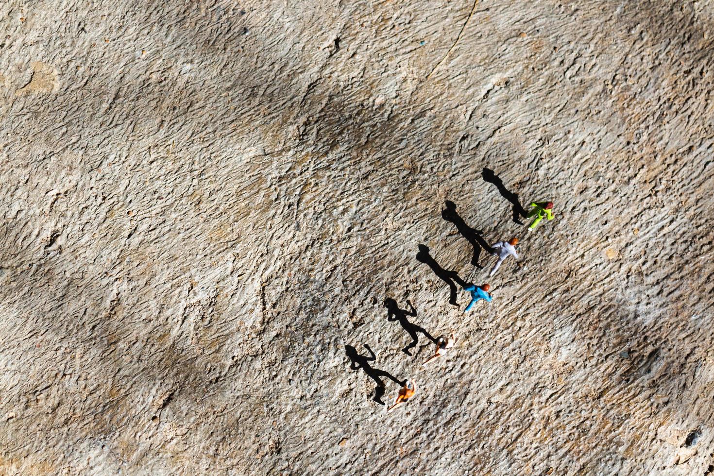 Grupo en miniatura de personas corriendo sobre un piso de concreto, concepto de estilo de vida saludable foto