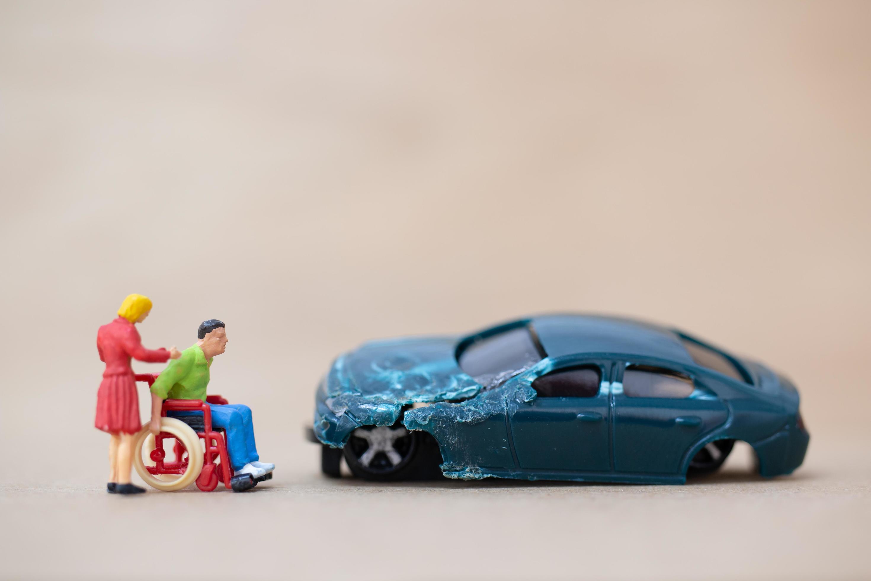 Miniature disabled man sitting in a wheelchair on a wooden background, car  accident concept 2131926 Stock Photo at Vecteezy