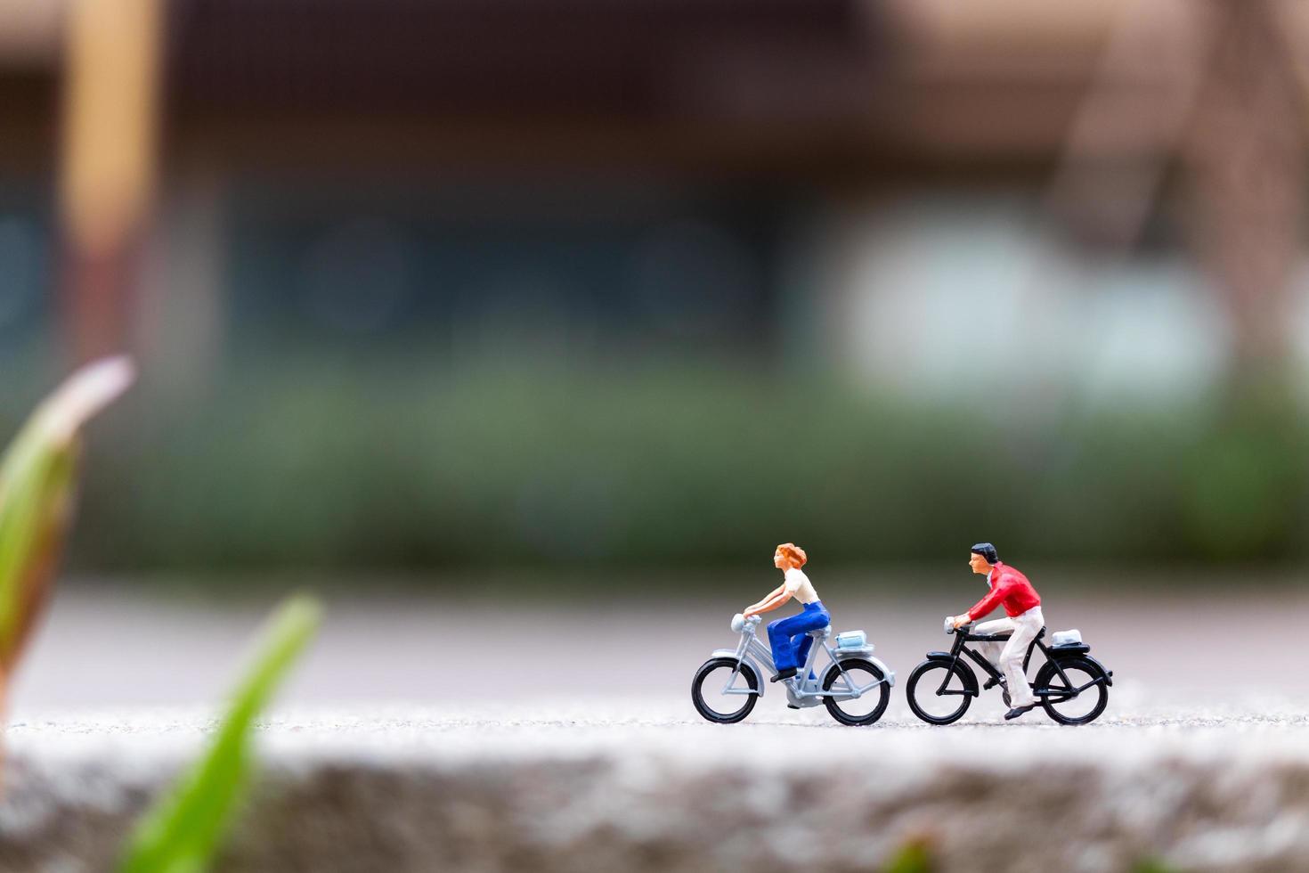 Viajeros en miniatura con bicicletas en el parque, concepto de estilo de vida saludable foto