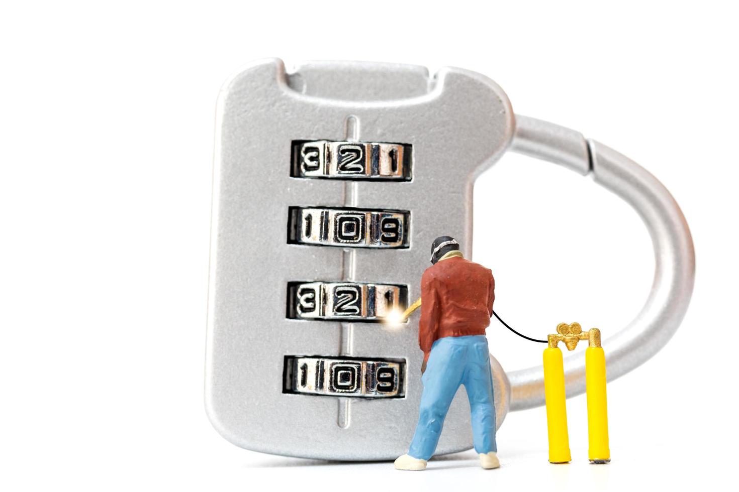 Miniature person working on a combination lock photo