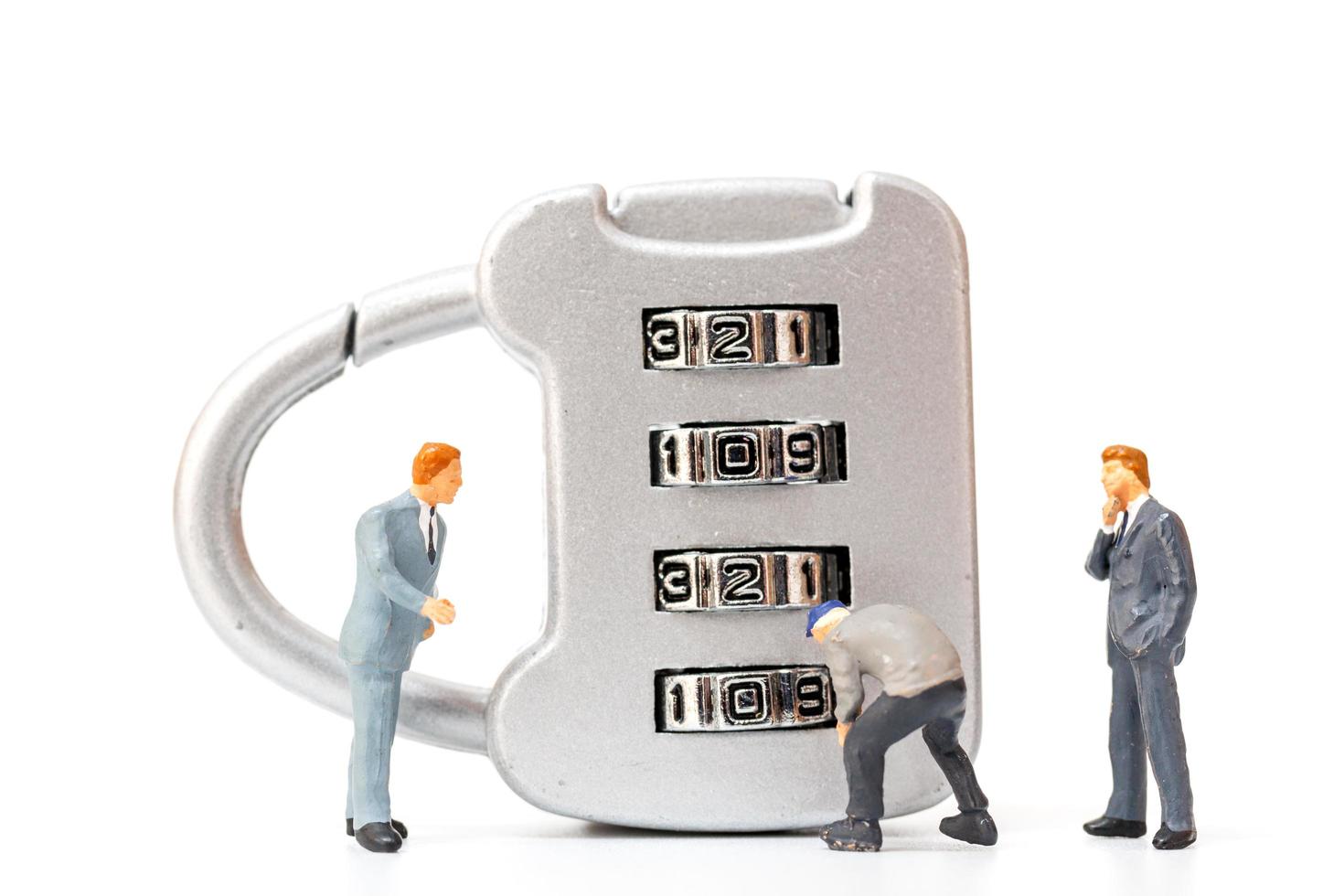 Miniature person working on a combination lock photo