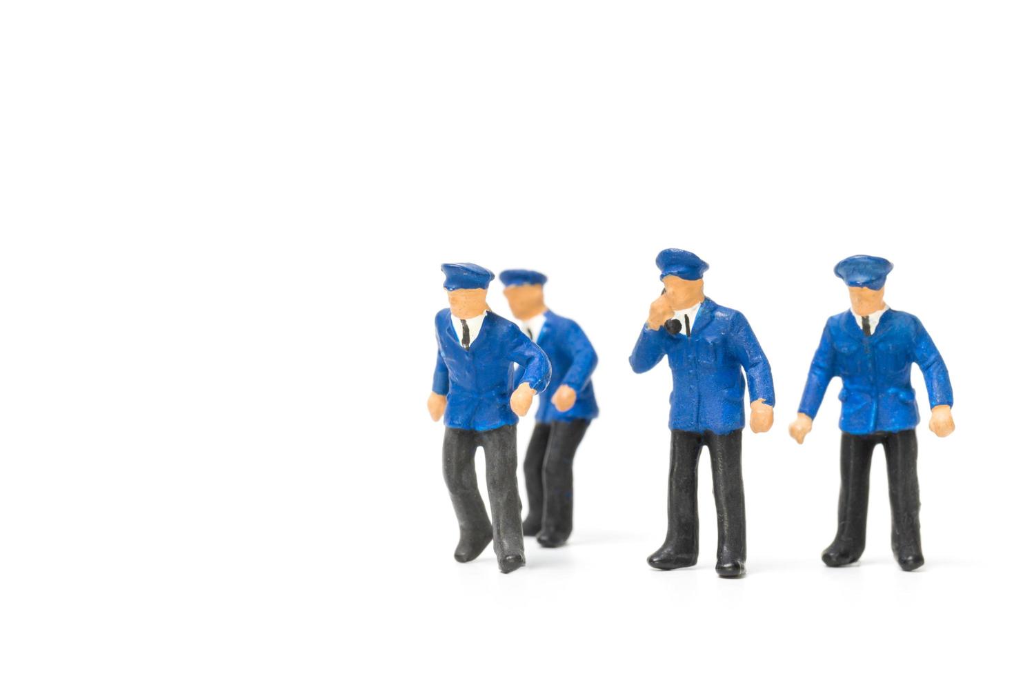 Miniature policemen standing isolated on a white background photo