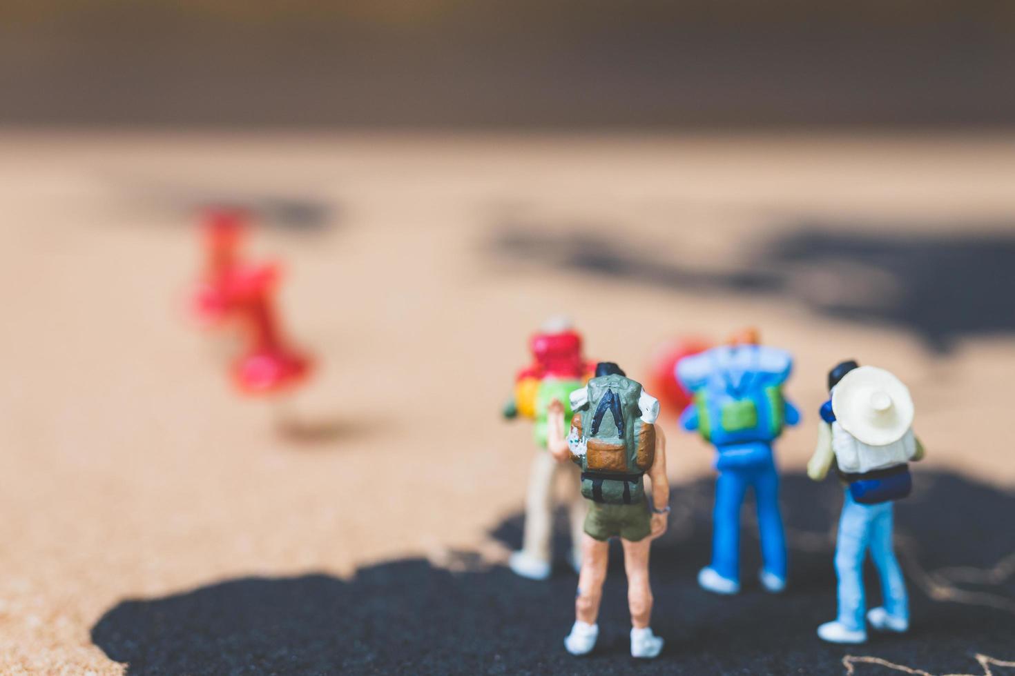 Mochileros en miniatura caminando sobre un mapa del mundo, concepto de turismo y viajes foto