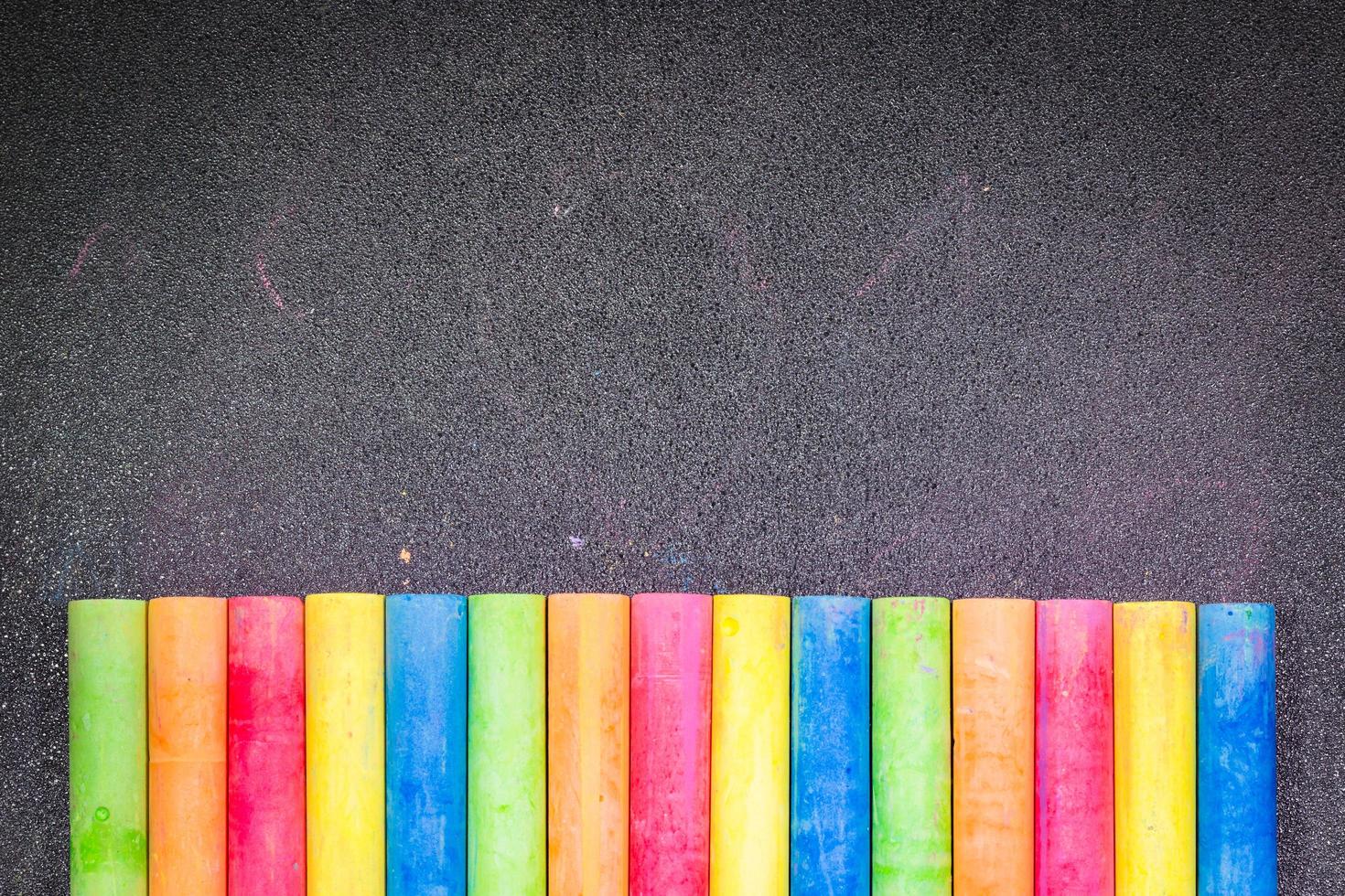 Row of rainbow colored chalk on a blackboard photo