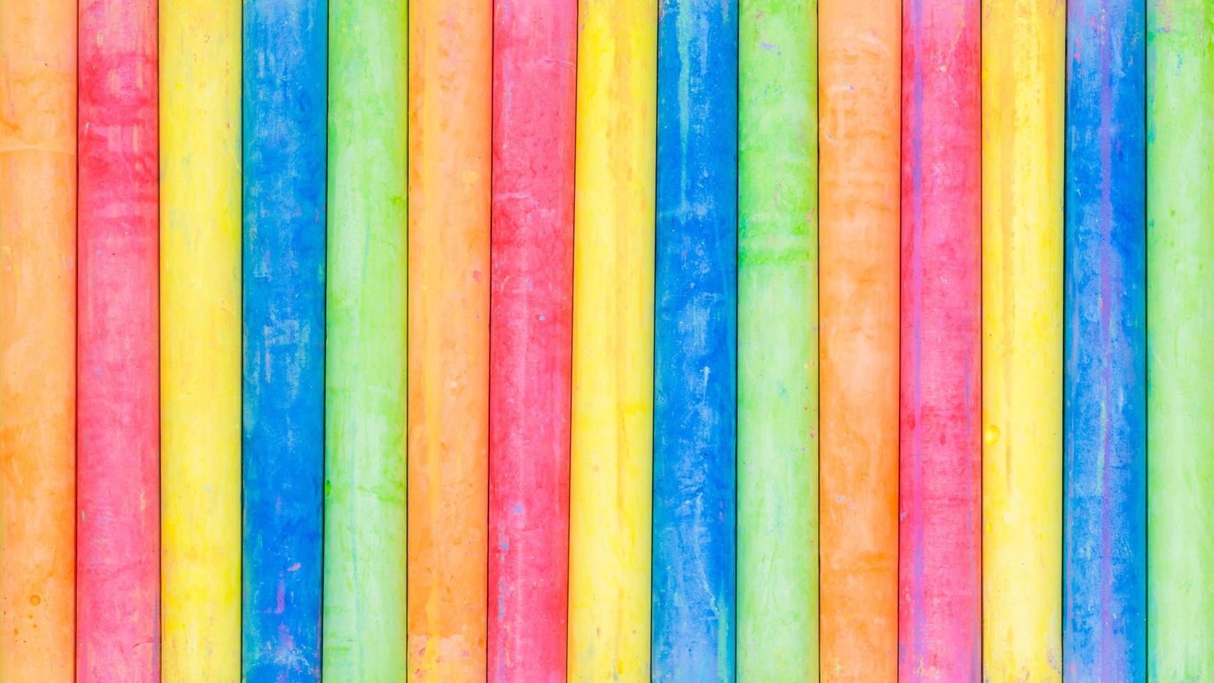 Fila de tiza de colores del arco iris en una pizarra foto