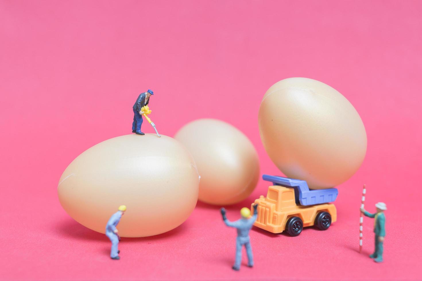 Gente en miniatura trabajando en huevos de pascua para pascua foto