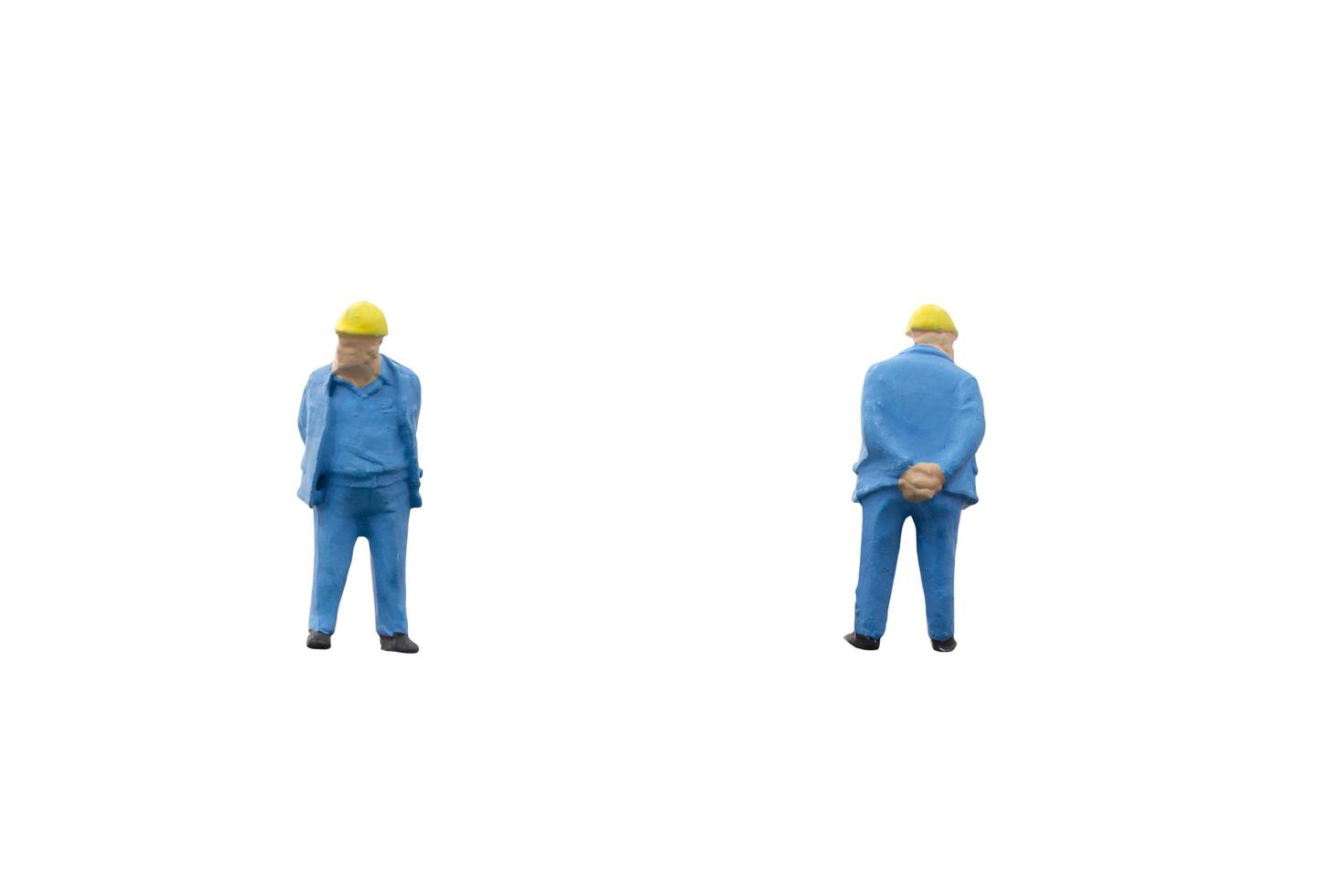 Miniature construction workers on a white background photo