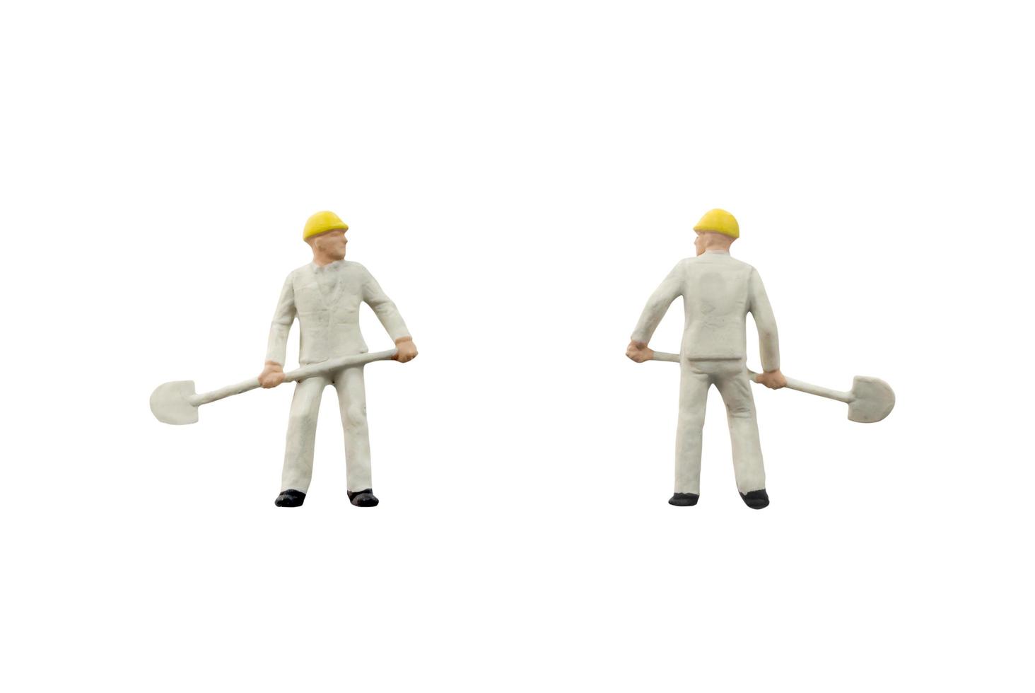 Miniature construction workers on a white background photo