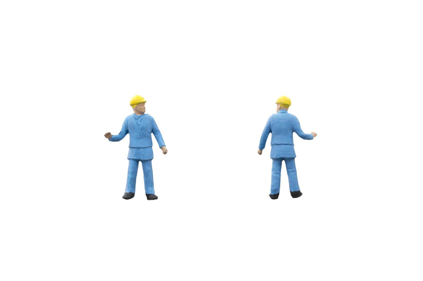 Miniature construction workers on a white background photo