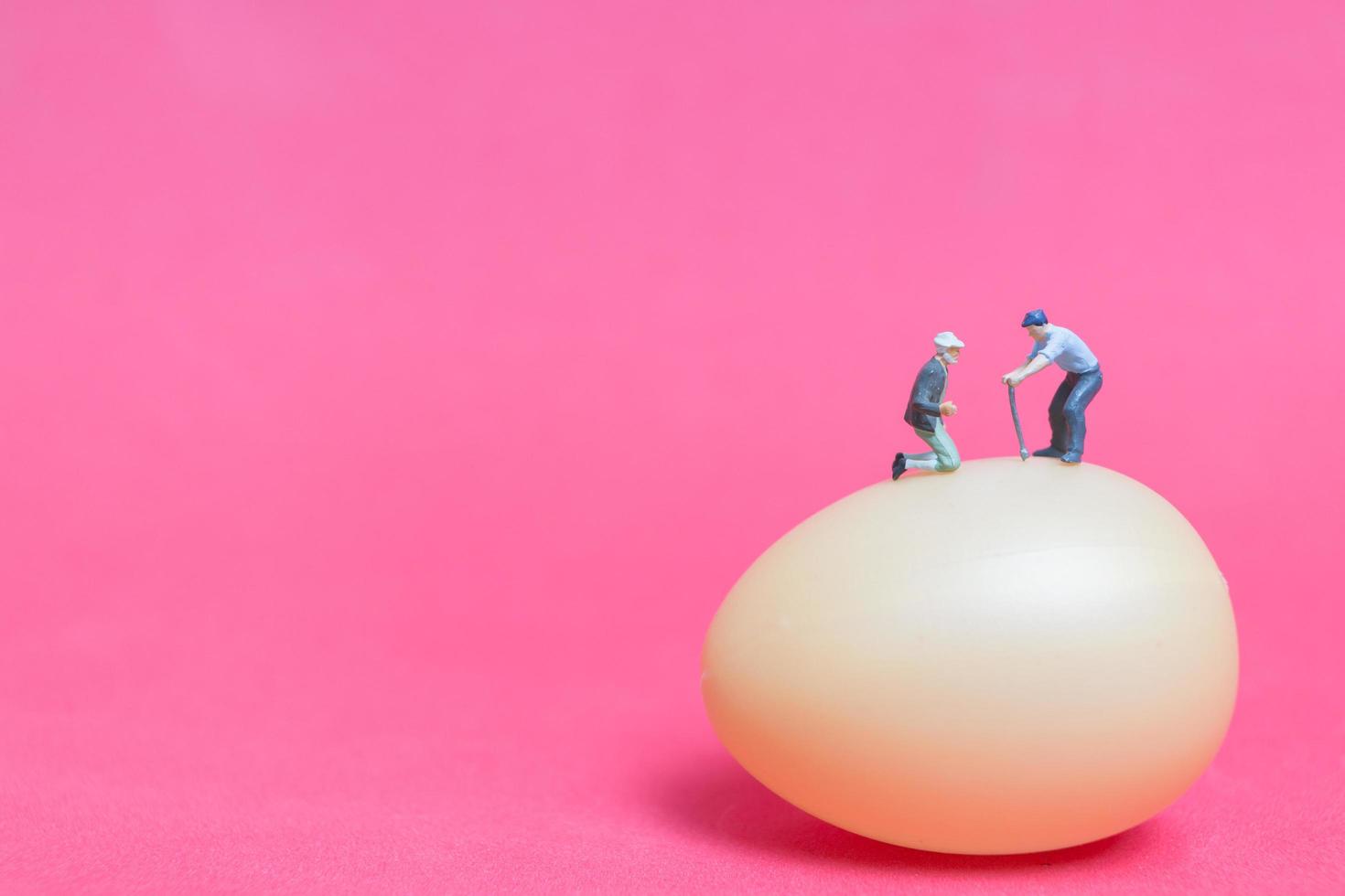 Gente en miniatura trabajando en huevos de pascua para pascua foto