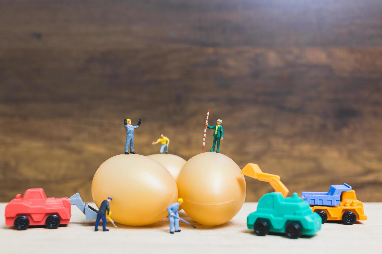 Gente en miniatura trabajando en huevos de pascua para pascua foto