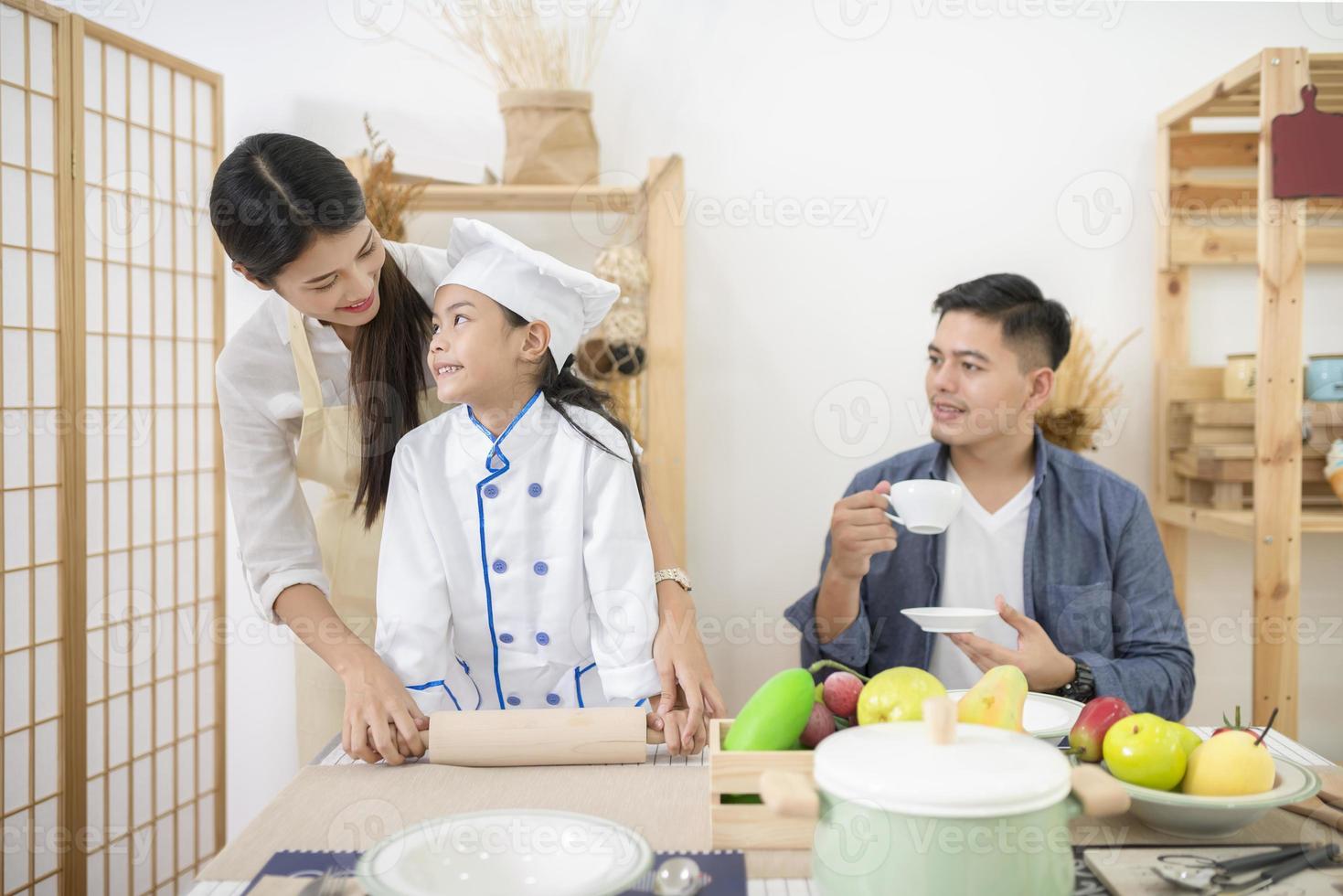 Happy family cooking biscuits together in kitchen photo