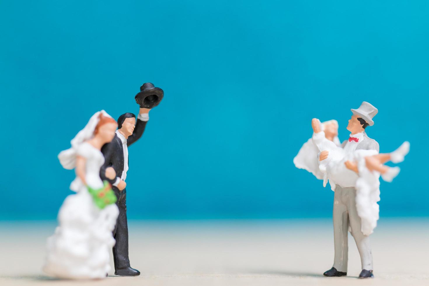 Parejas en miniatura sobre un fondo azul. foto