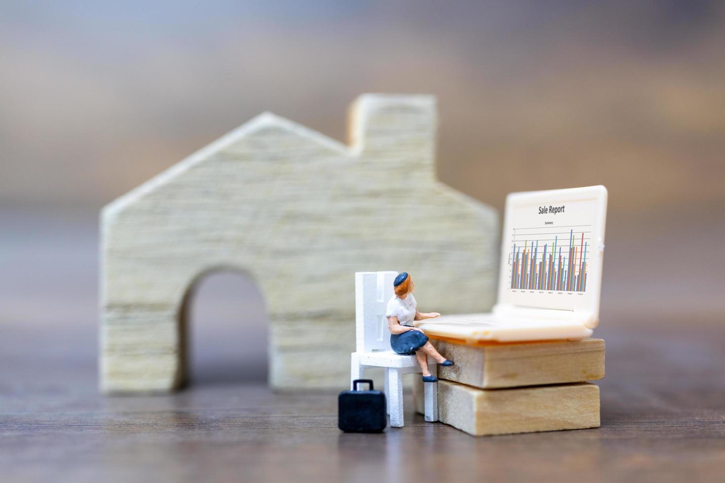 Miniature person working on a computer laptop, work at home concept photo