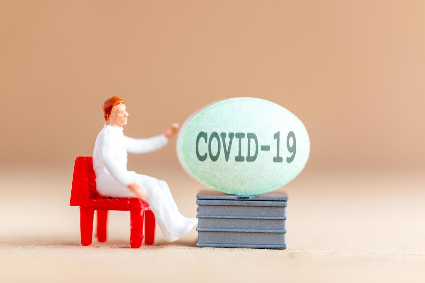 Miniature doctor researching and developing a Coronavirus vaccine, medicine to stop the COVID-19 outbreak concept photo