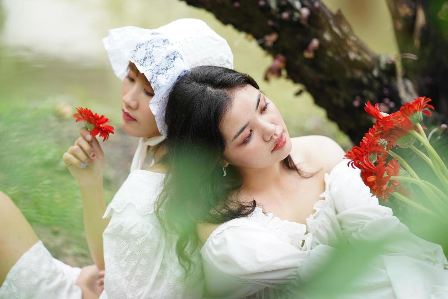 Two women and red flowers photo