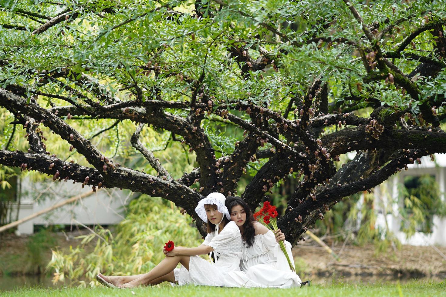 dos mujeres vestidas de blanco y sosteniendo flores foto