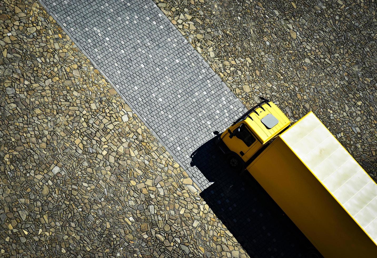 Yellow truck on stone pavement photo
