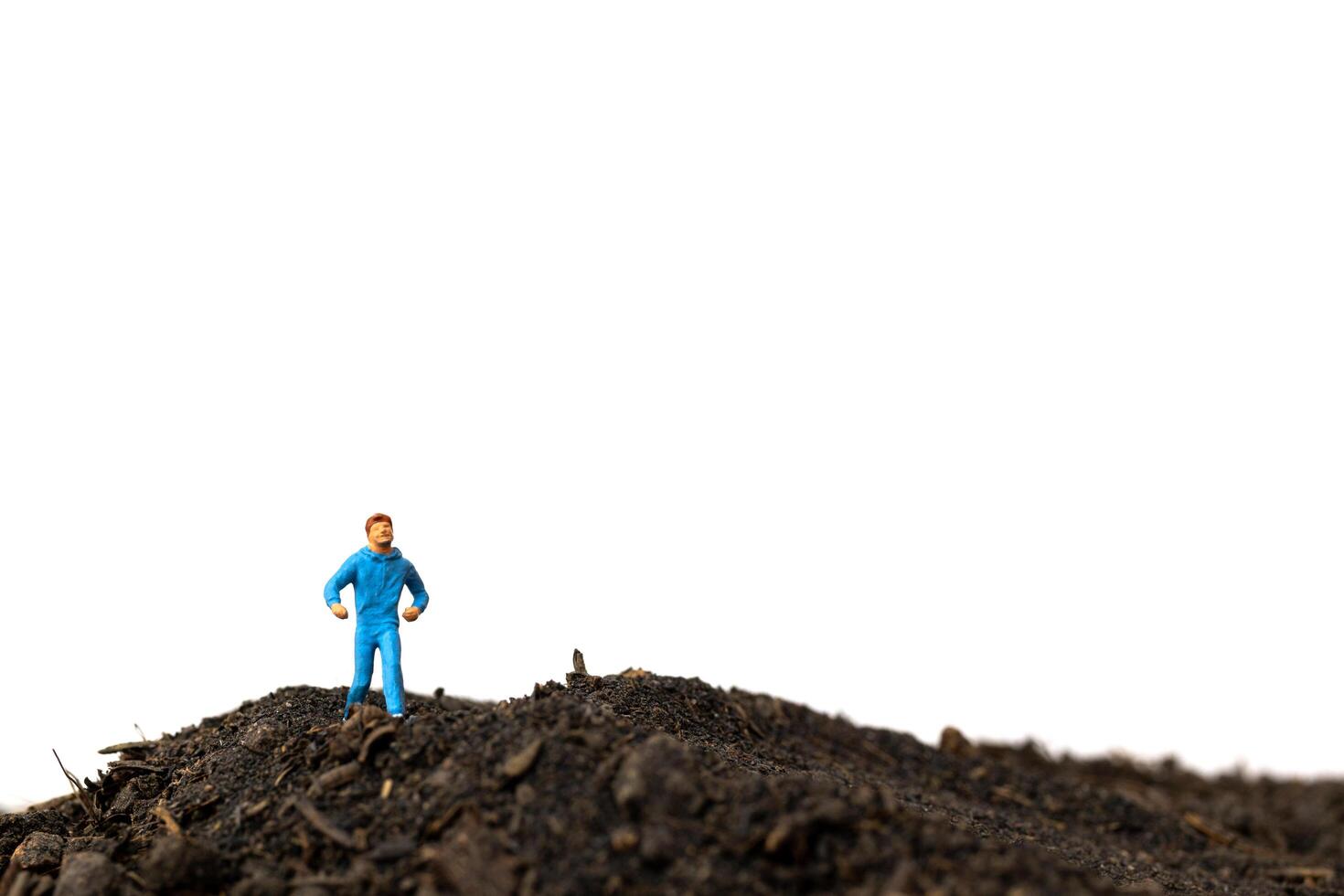 Miniature man running on the ground isolated on a white background, running for health concept photo