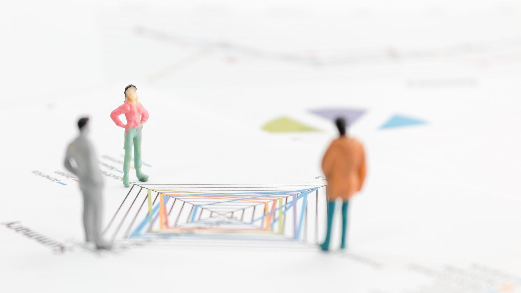 Miniature businesspeople standing on a graph chart photo