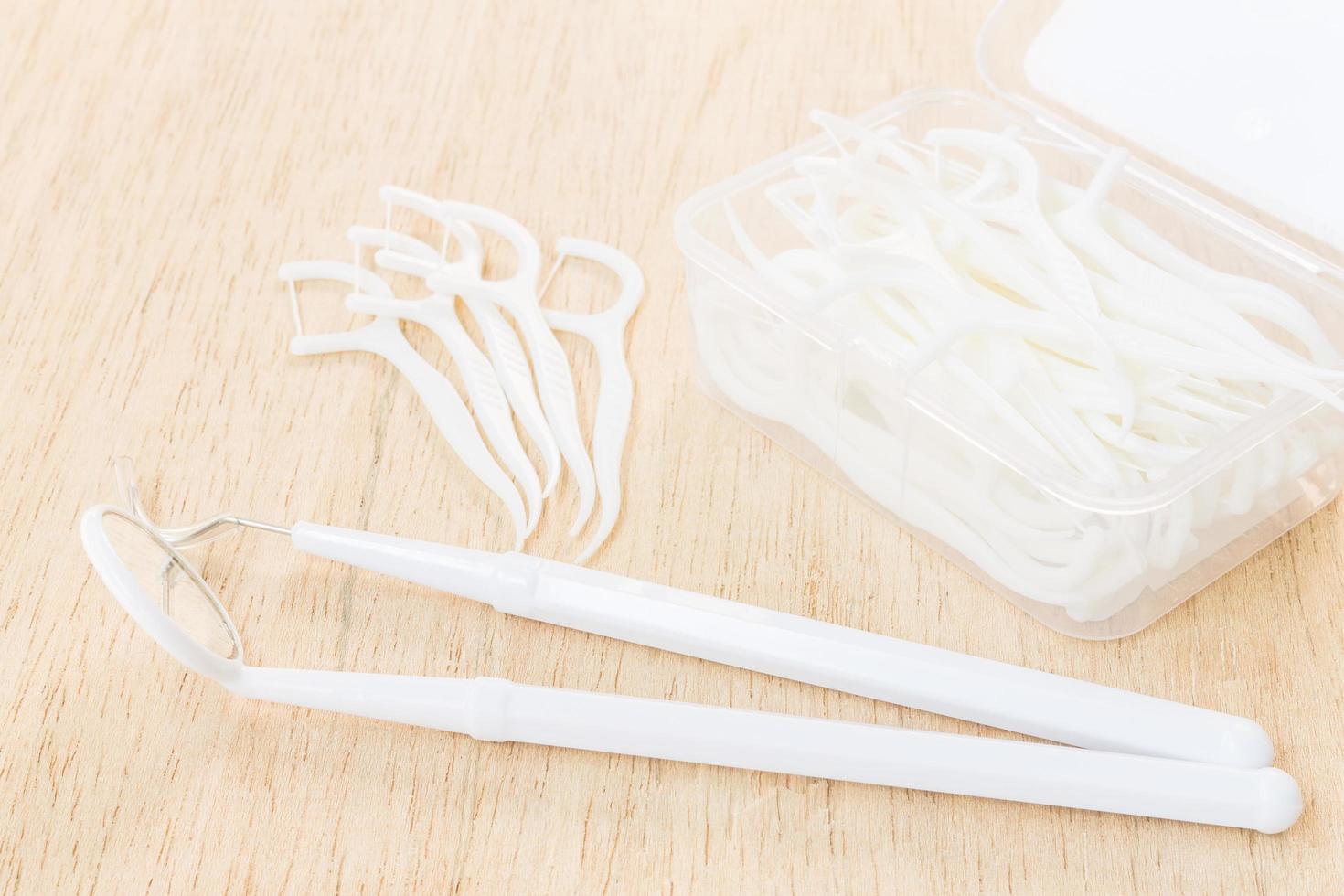 A box of white dental floss on a wooden background photo