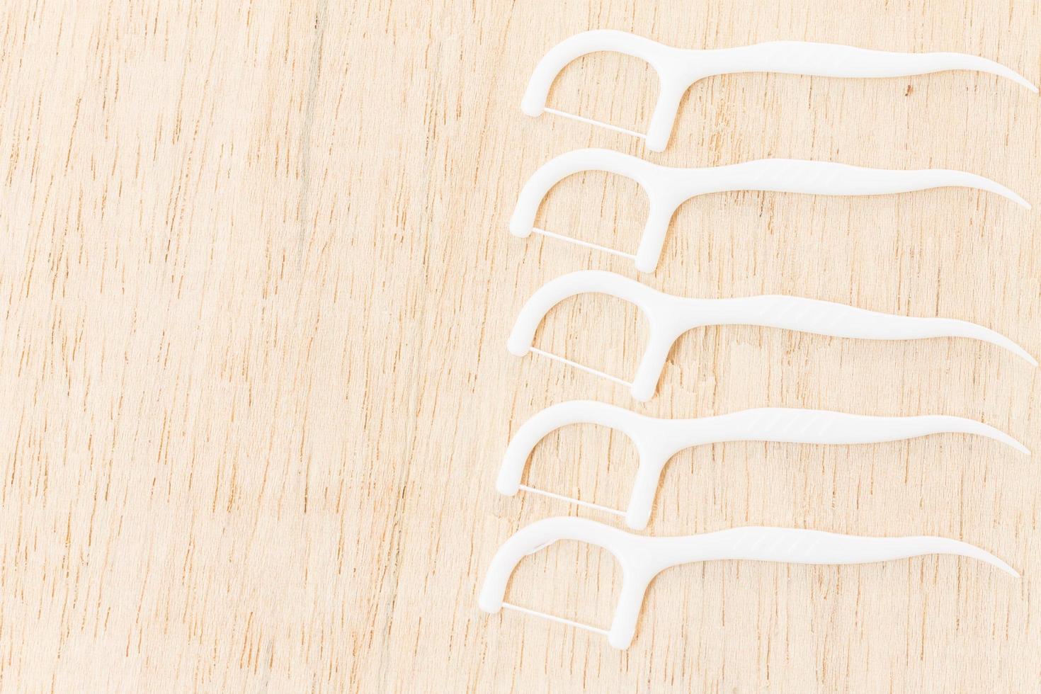 White dental floss on a wooden background photo