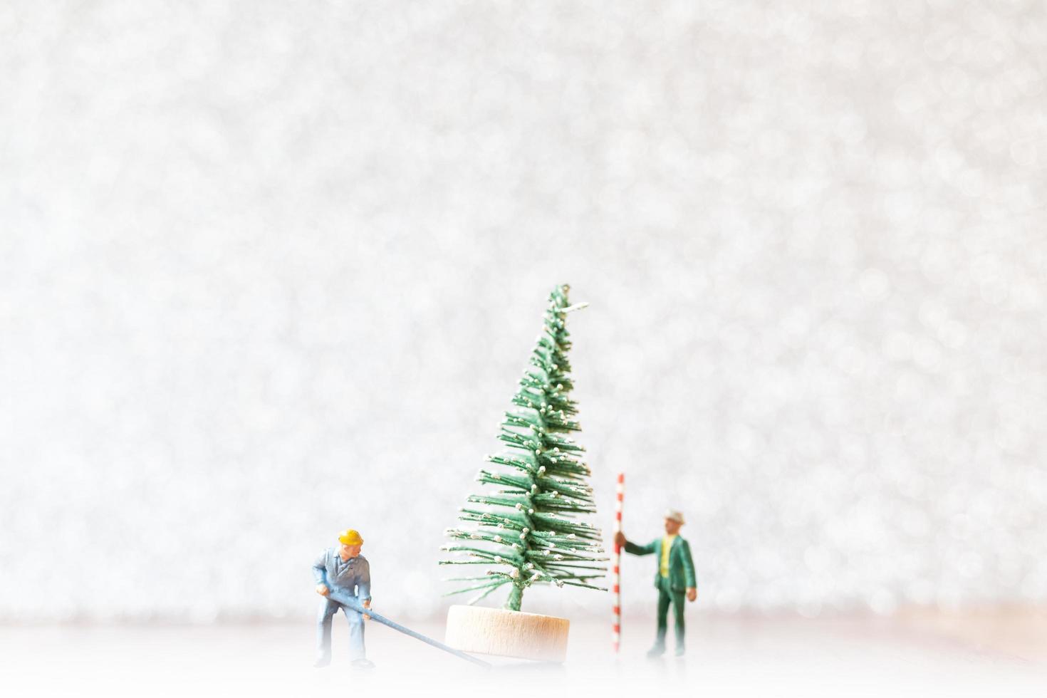 Miniature workers preparing a Christmas tree, Christmas decoration concept photo