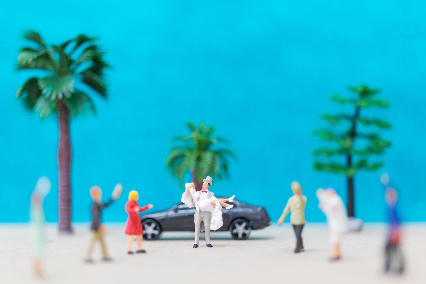 La novia y el novio en miniatura en una playa, concepto de boda foto