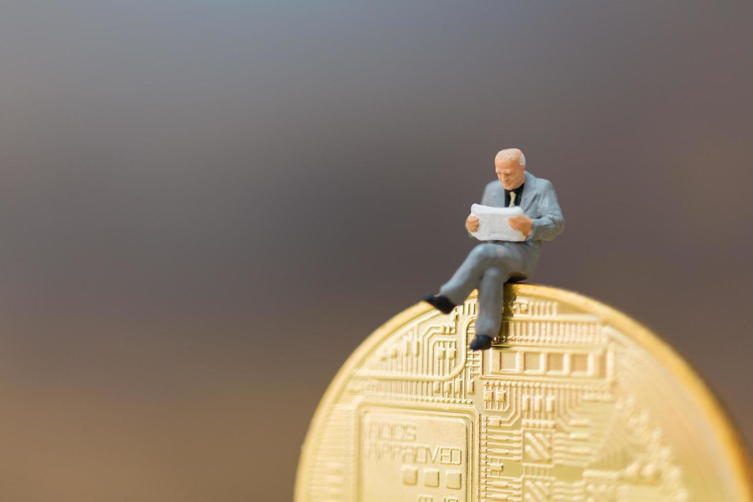 Miniature businessman sitting on a digital coin, business concept photo