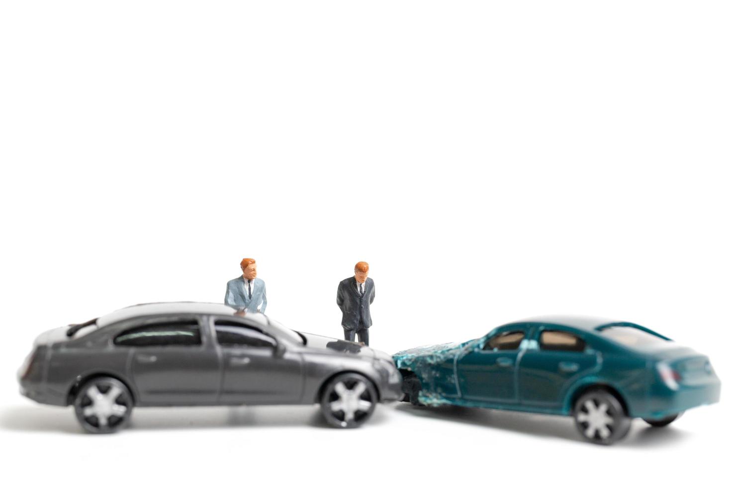 Miniature people at the scene of a car accident, car crash on a white background, drive safely concept photo