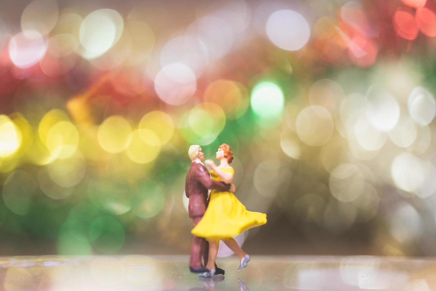 Pareja en miniatura bailando románticamente con un fondo bokeh, vida nocturna y concepto de personas foto