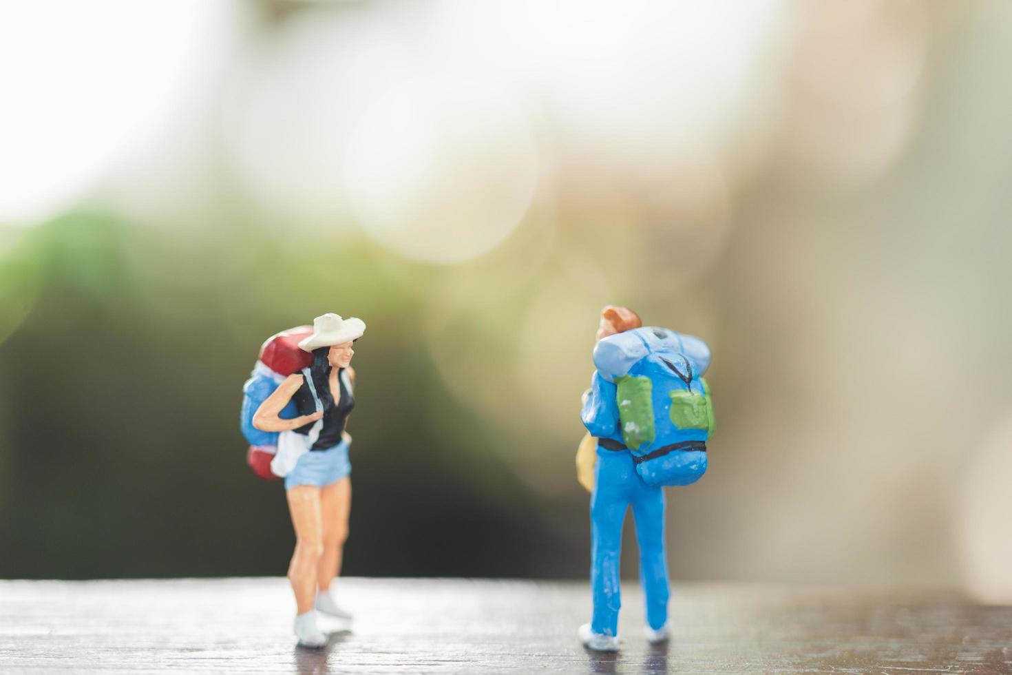 Gente en miniatura con mochilas de pie y caminando, concepto de viaje y aventura. foto