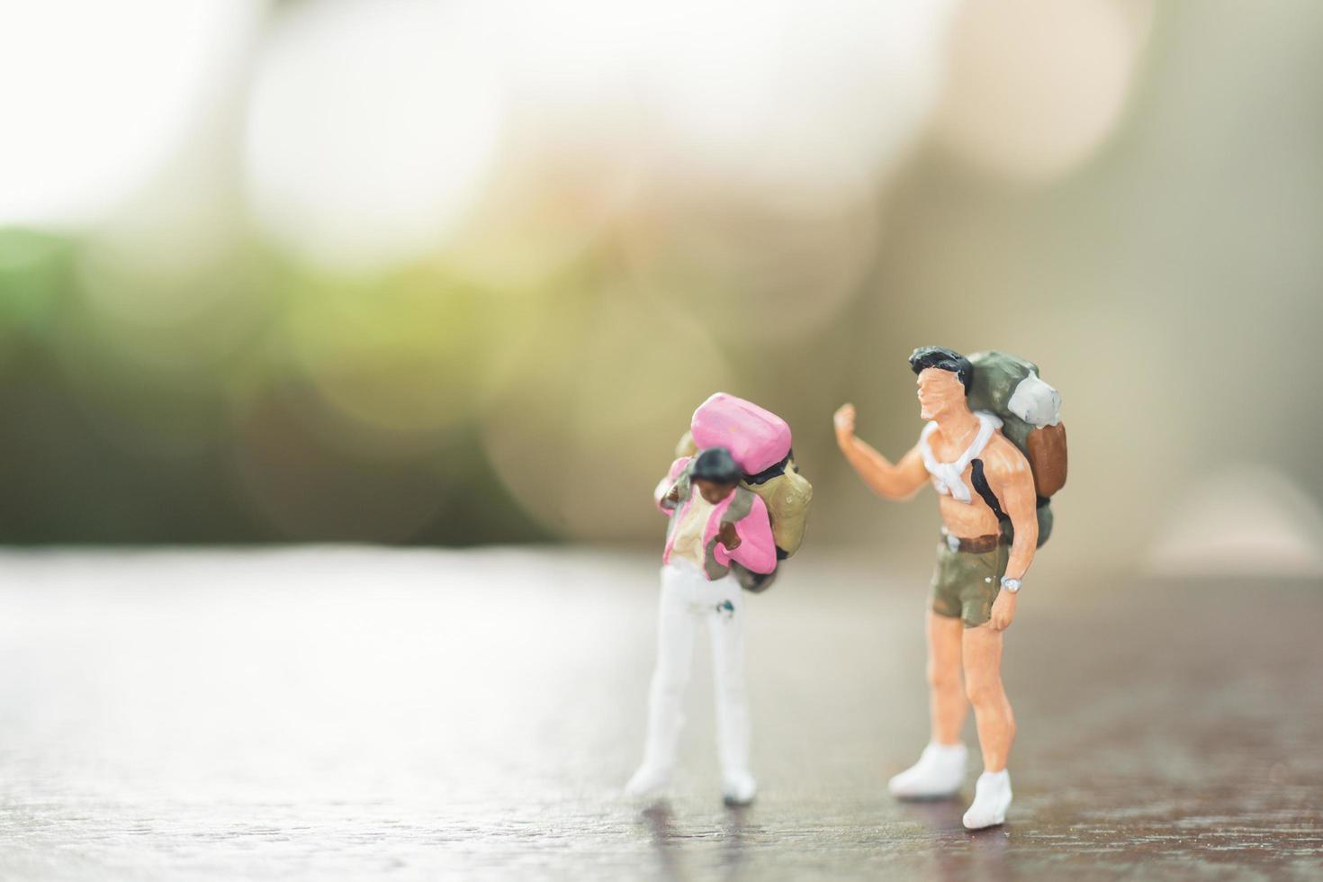 Miniature people with backpacks standing and walking, travel and adventure concept photo