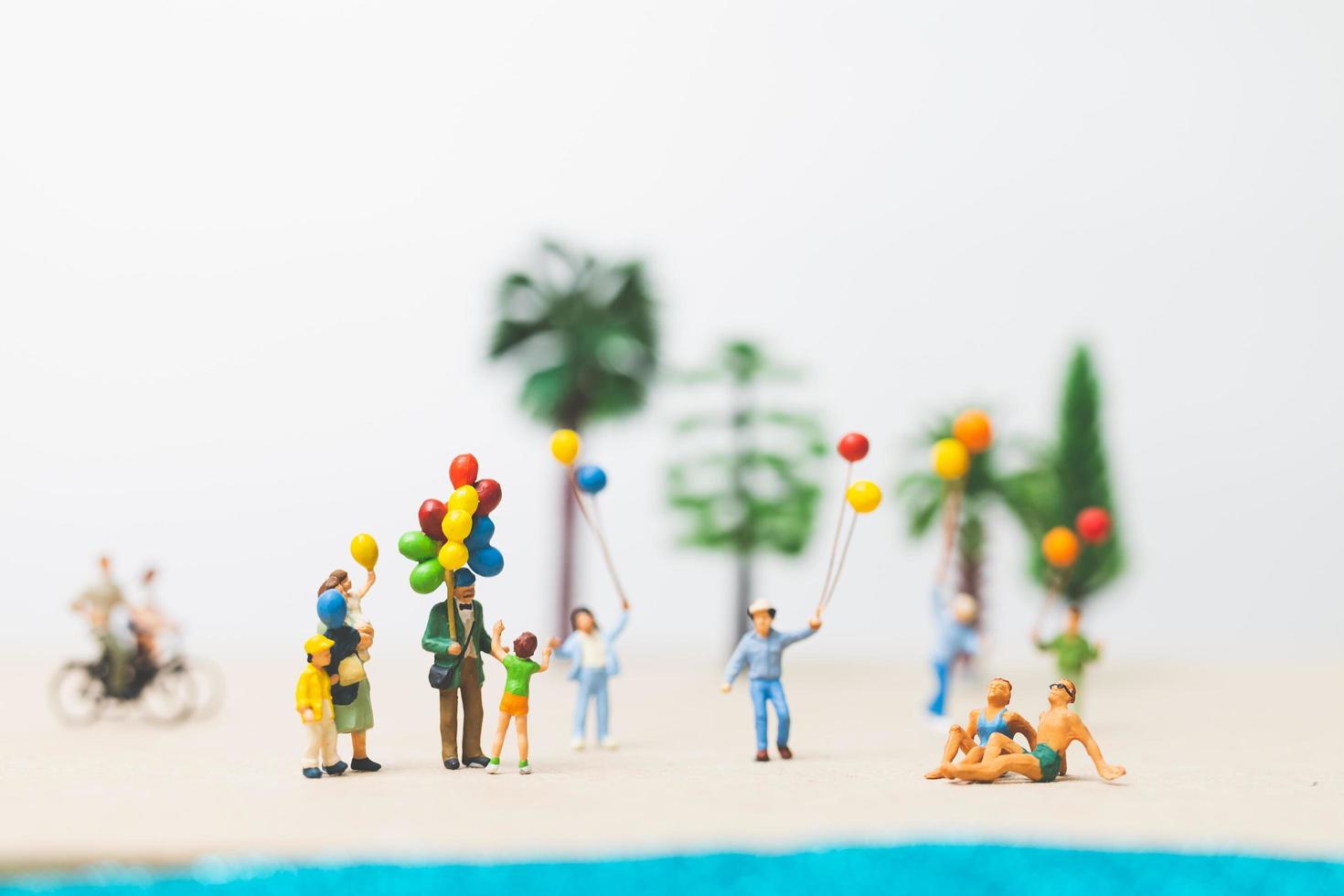 Gente en miniatura disfrutando de las vacaciones de verano en la playa. foto