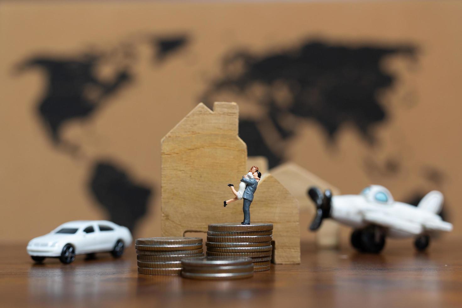 Miniature couple with a lot of money, a car, house, and airplane, successful concept photo