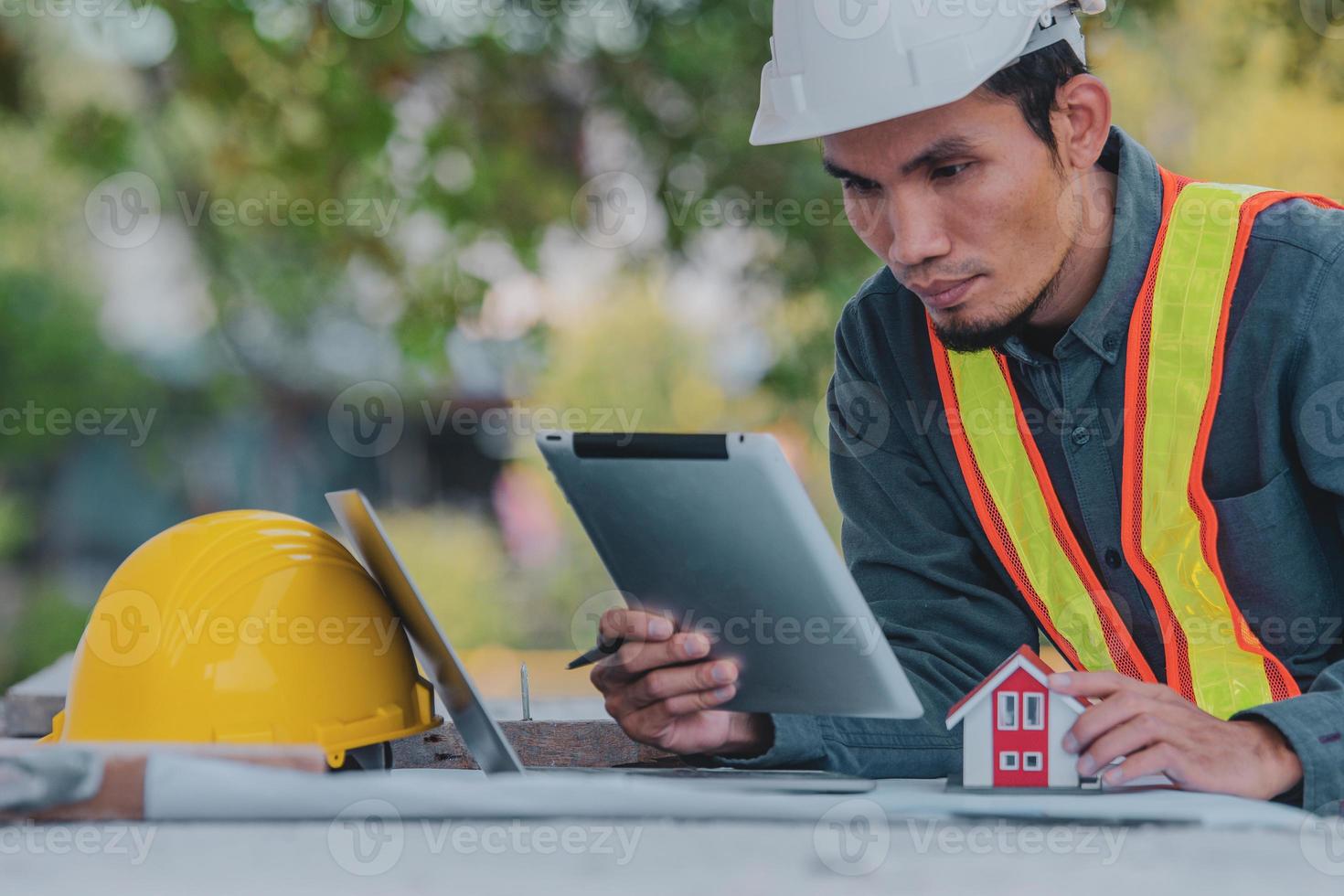 Engineer working on tablet and laptop on site construction photo