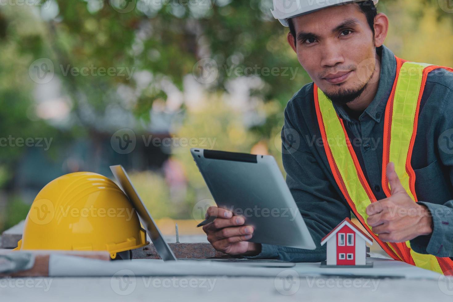 Ingeniero que trabaja en una tableta y un portátil en la construcción del sitio foto