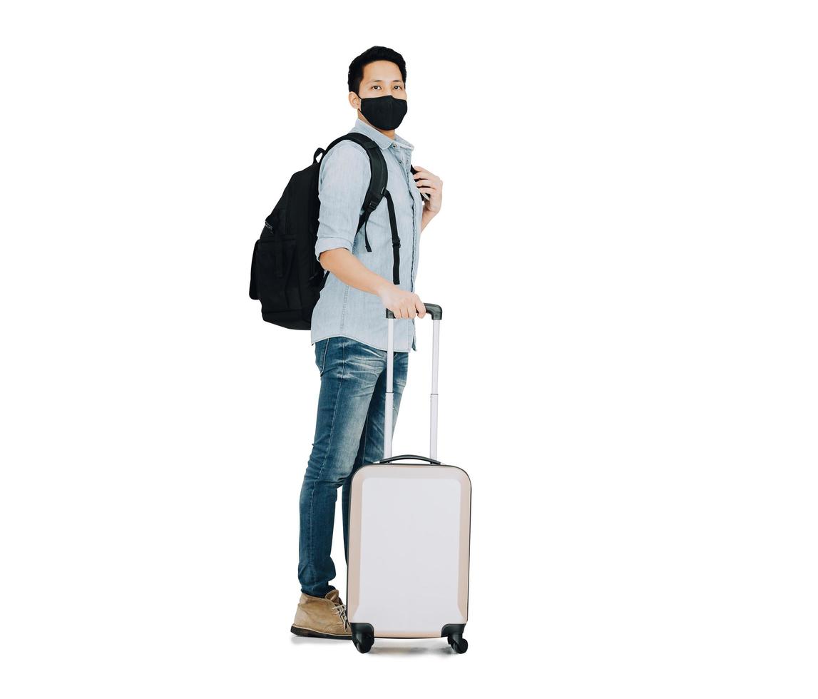 Hombre turista vistiendo mascarilla de pie con equipaje foto