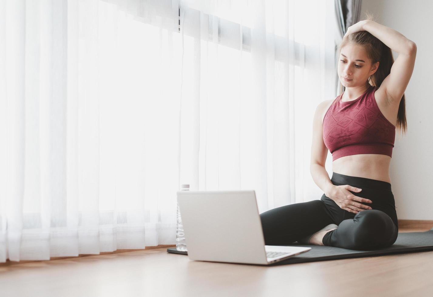 Woman learned online workout exercise class at home from laptop photo