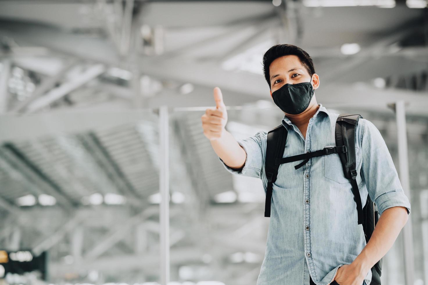 Asian man wearing mask protect from coronavirus showing thumb up photo