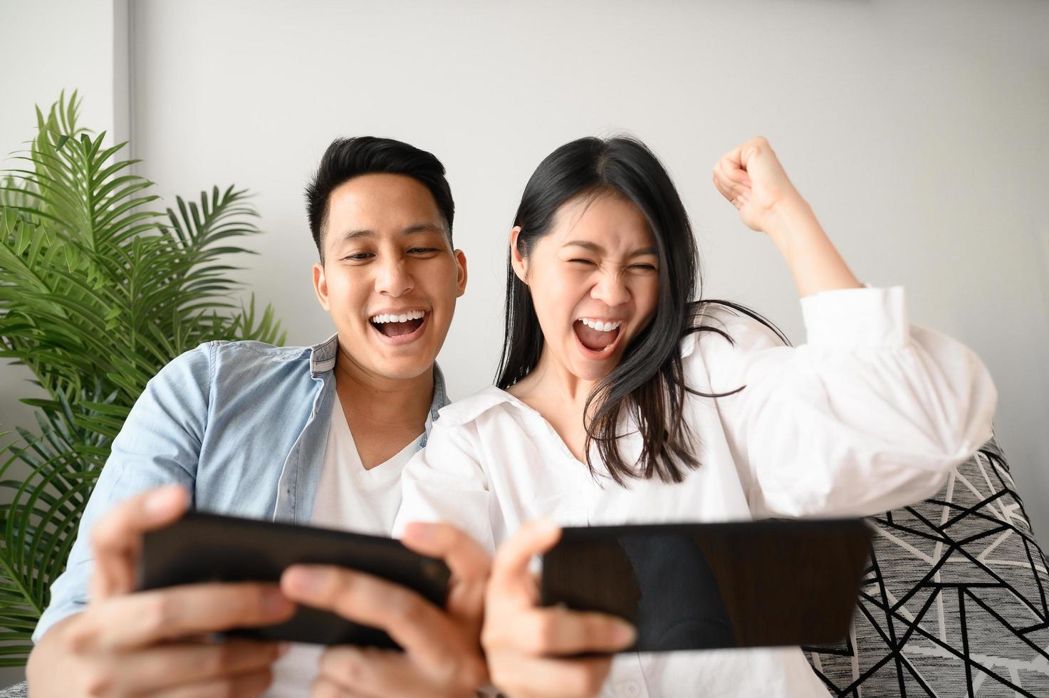 Couple having fun playing games on smartphone photo