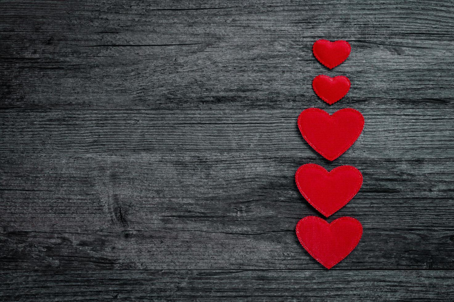 Red heart column on dark old wooden background photo