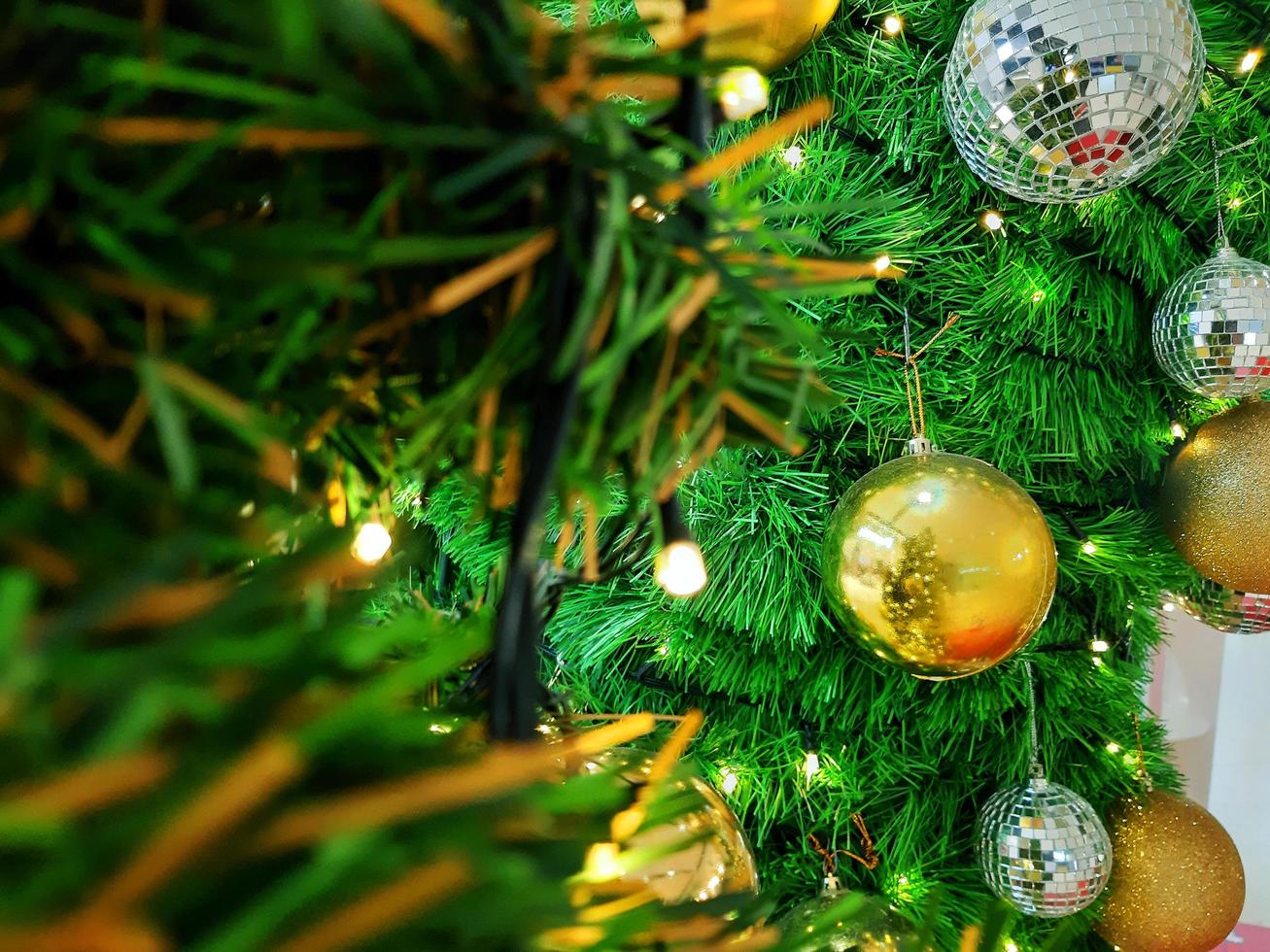 Bola de Navidad colgando de ramas de pino con un fondo festivo foto