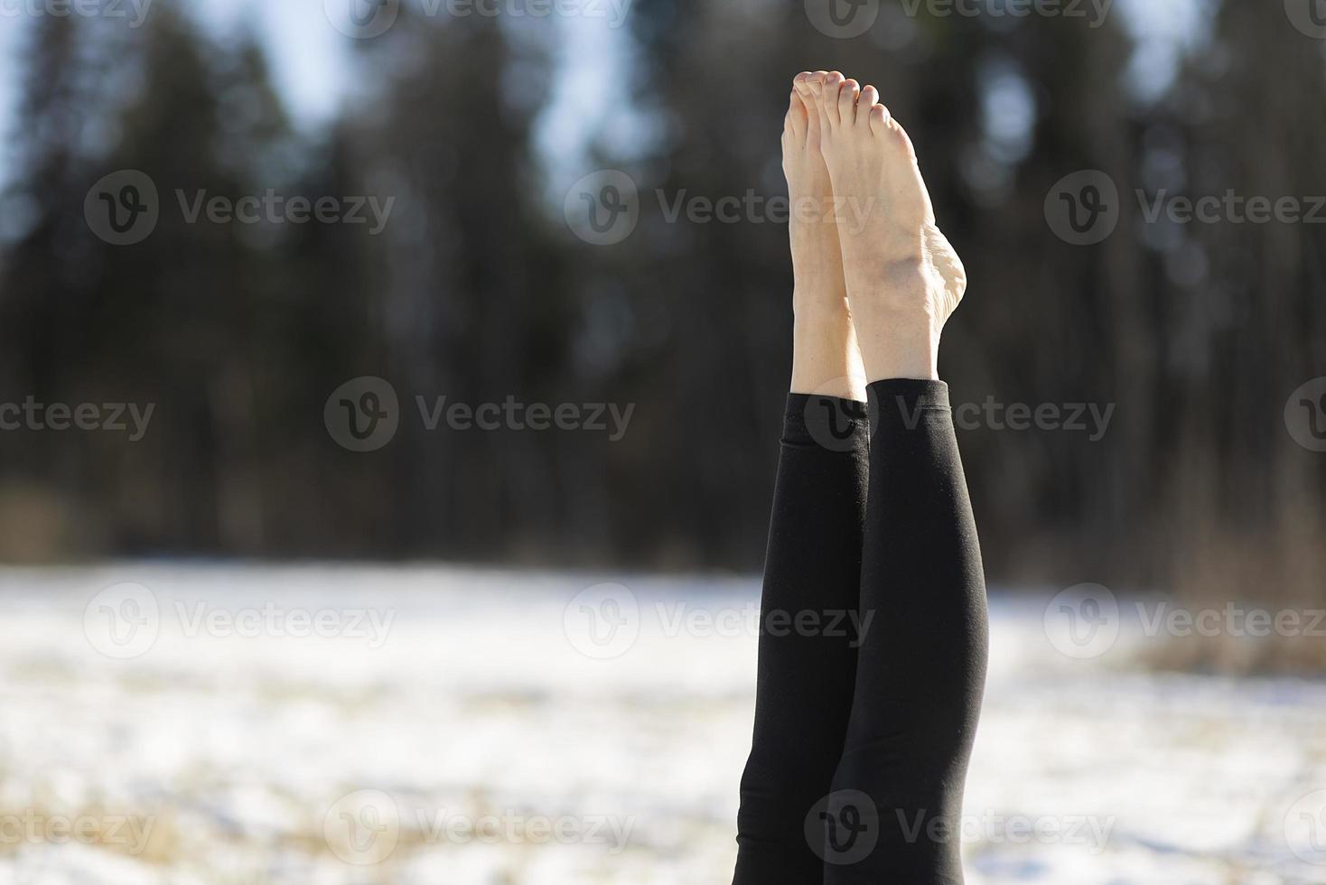 A young athletic woman performs yoga and meditation exercises outdoors photo