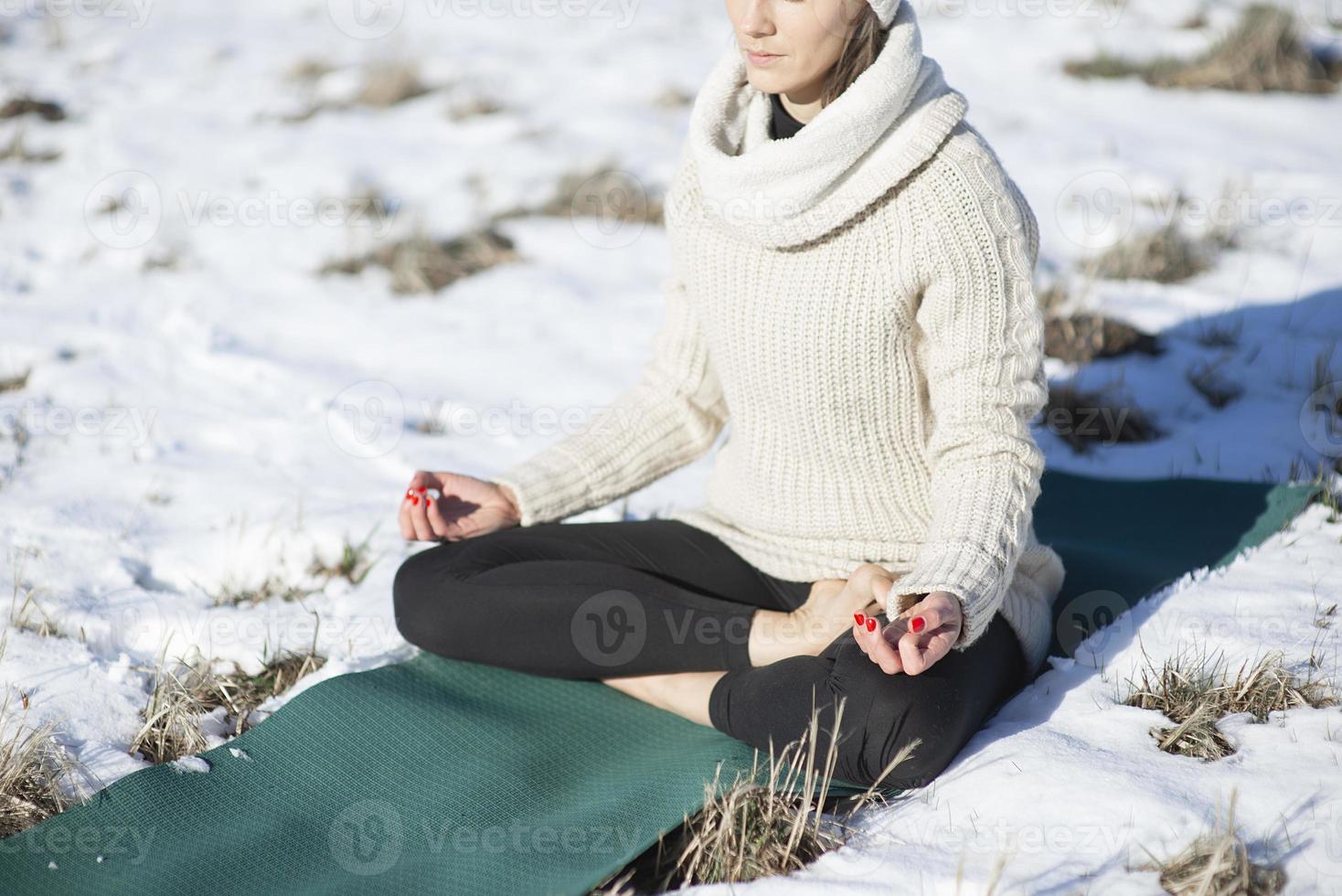 A young athletic woman performs yoga and meditation exercises outdoors photo