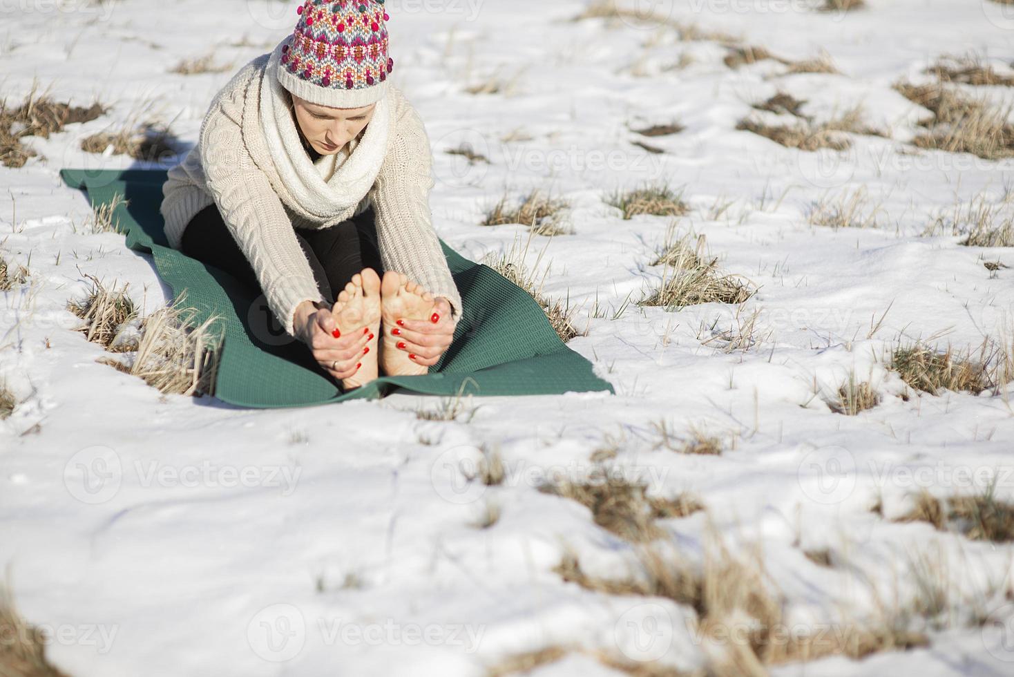 A young athletic woman performs yoga and meditation exercises outdoors photo