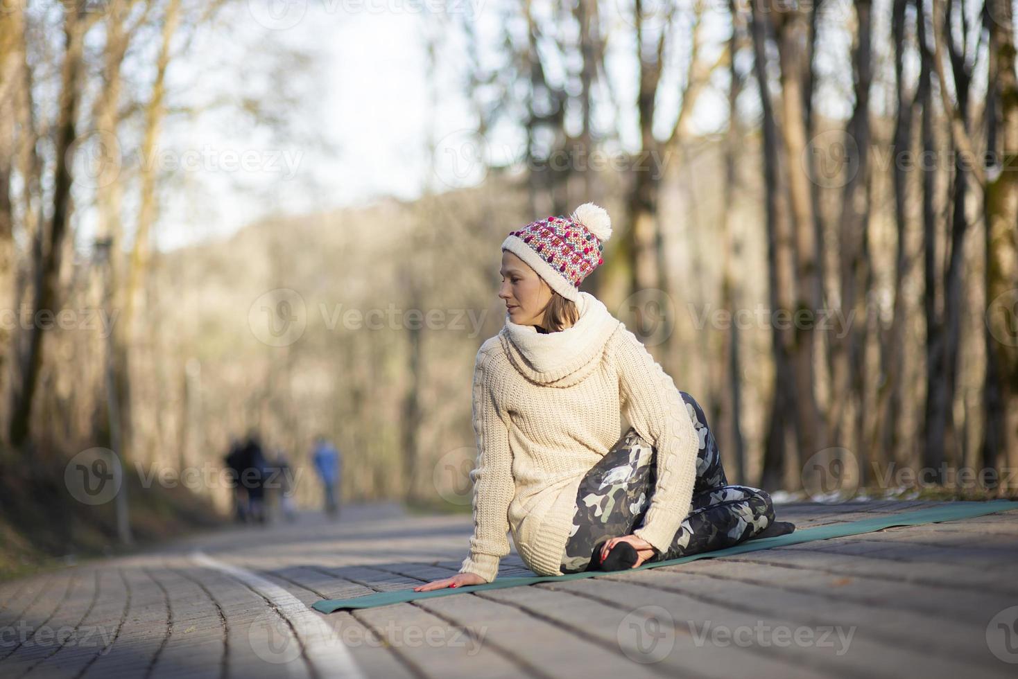 A young athletic woman performs yoga and meditation exercises outdoors photo