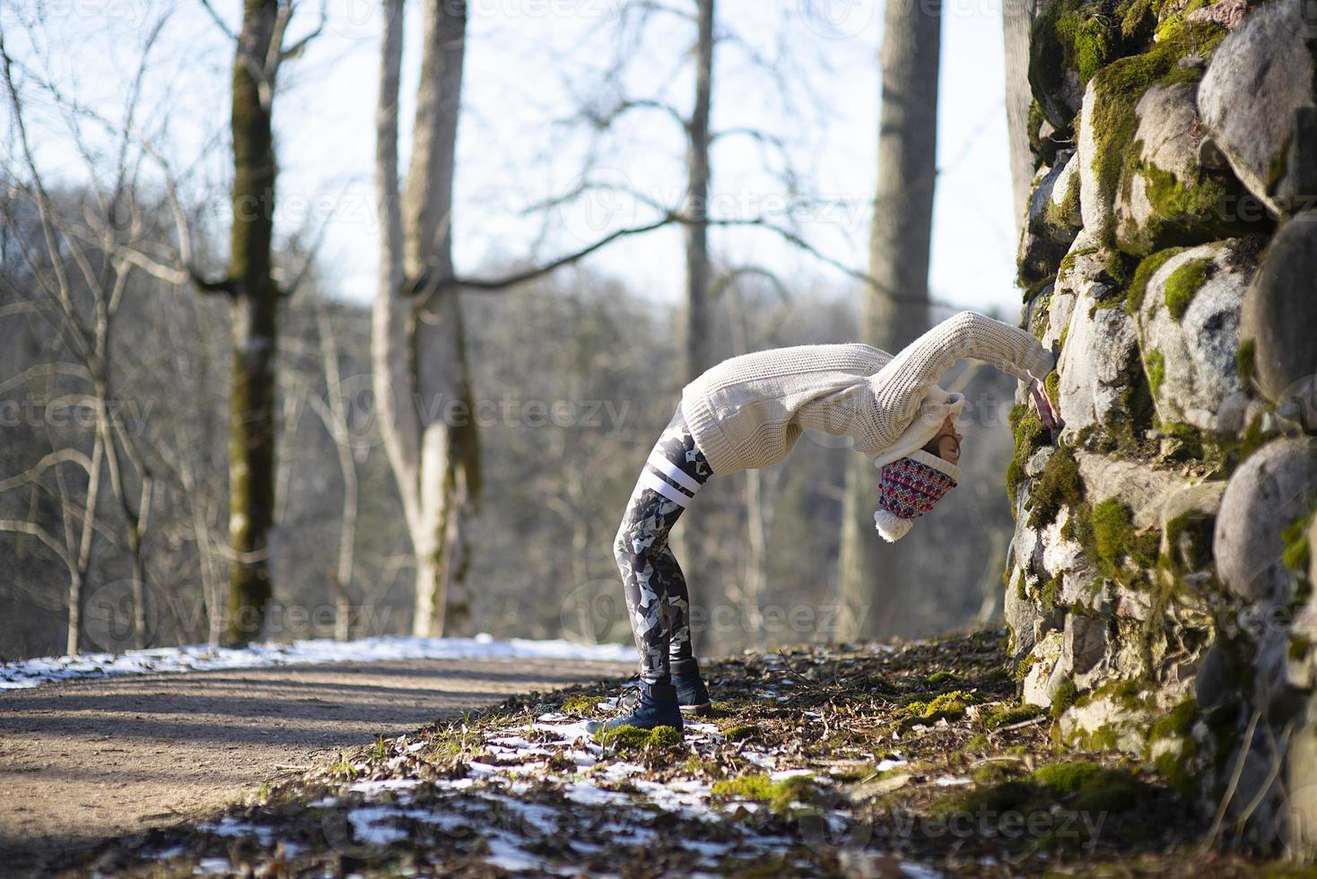 A young athletic woman performs yoga and meditation exercises outdoors photo