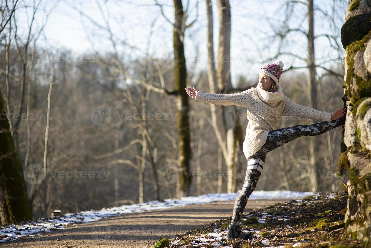 A young athletic woman performs yoga and meditation exercises outdoors photo